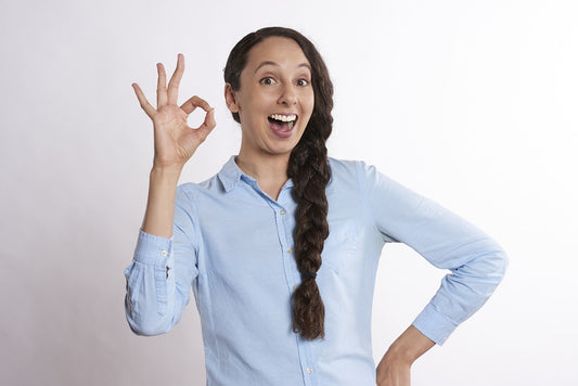 Mujer haciendo el gesto de OK, simbolizando el bienestar emocional y la positividad en torno a la sexualidad saludable.